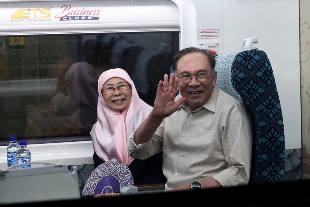 Prime Minister Datuk Seri Anwar Ibrahim and his wife Datuk Seri Dr Wan Azizah Wan Ismail wave after boarding the ETS at JB Sentral following a family visit to Johor in Johor Bahru on February 2, 2026. — Bernama pic