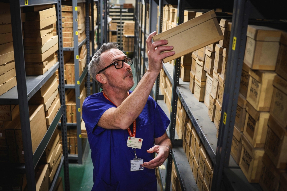 This photo taken on January 14, 2026 shows consultant gastroenterologist Kevin Monahan looking through samples in a storeroom at St Mark's hospital at Northwick Park in Harrow, west London. — AFP pic