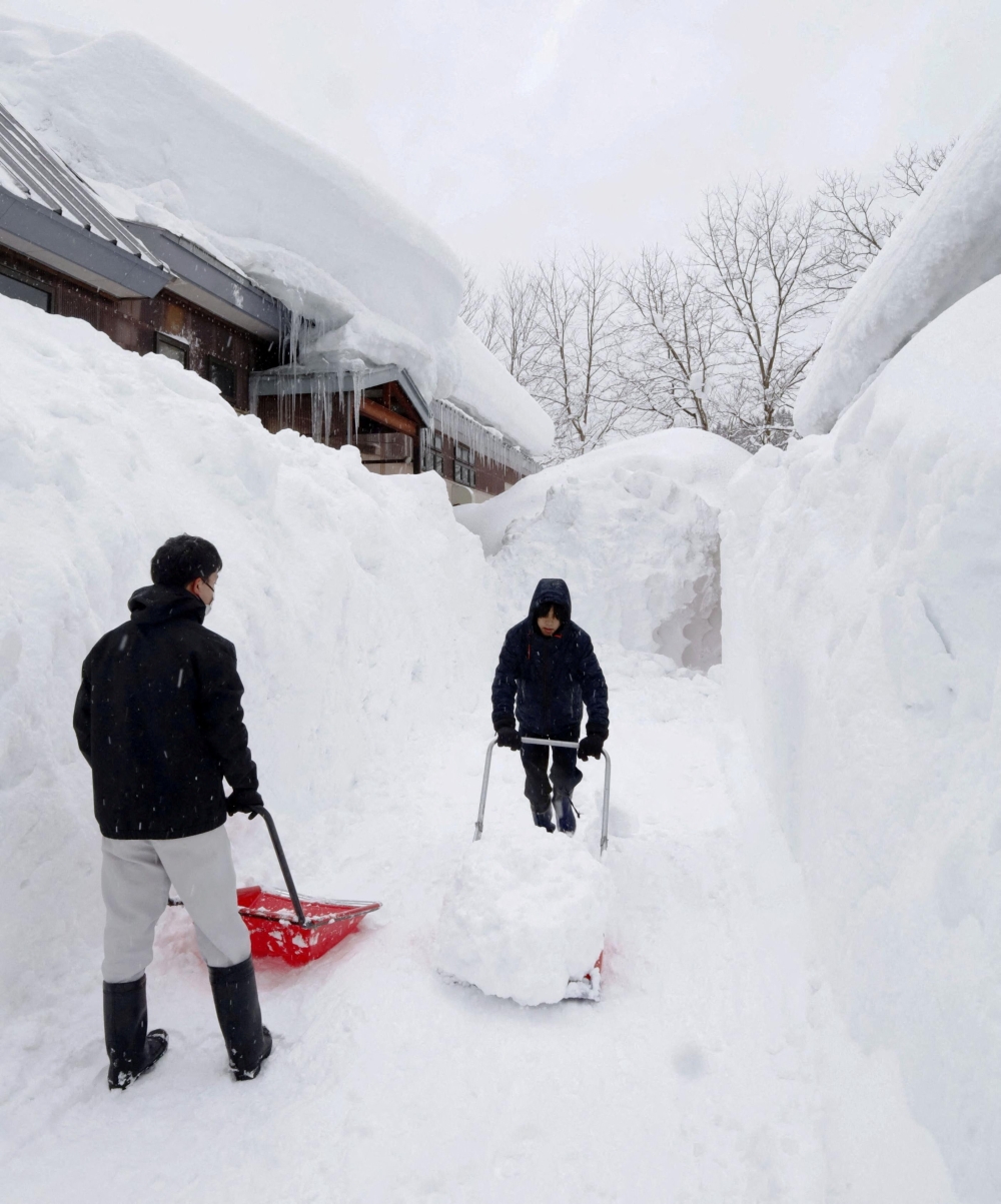 People remove snow near a house in Aomori, north-eastern Japan, as heavy snow continues to hit the region, February 2, 2026. — Kyodo pic via Reuters 