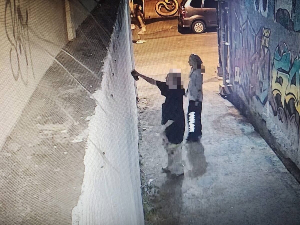 CCTV footage shows two suspects spray-painting the outer wall of Wat Dok Euang in Chiang Mai in the early hours of January 30. — Chiang Mai police