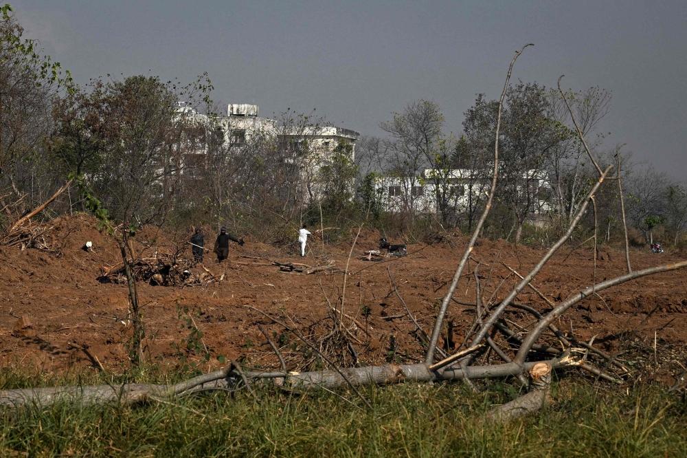 This photograph taken on January 7, 2026 shows workers felling trees near a housing construction site in Islamabad. — AFP pic