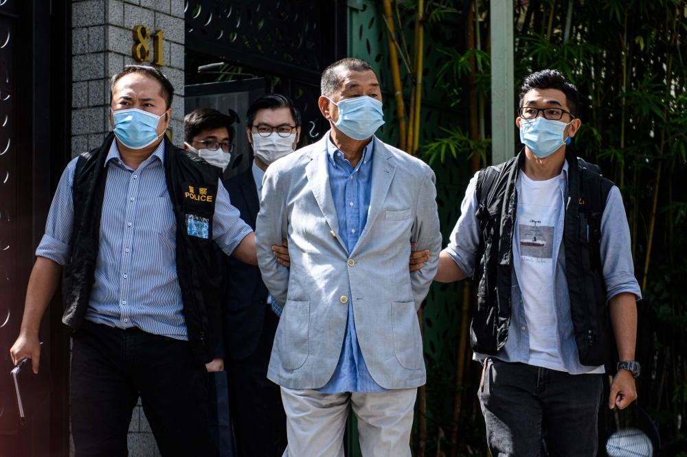 Apple Daily founder Jimmy Lai (centre) has been sentenced to 20 years in prison after being convicted of colluding with foreign powers and sedition in a landmark case testing Hong Kong’s press freedom laws. — AFP pic