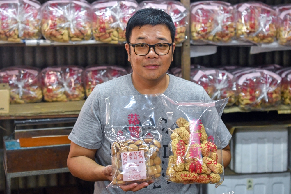Lee Su Wei, 46, owner of a traditional ‘kuih’ factory, displays ‘mua lau’ (right) and ‘kesanih’ biscuits sold ahead of the Chinese New Year celebrations at Kampung Cina near Gok Kapur Market, Kota Bharu. — Bernama pic