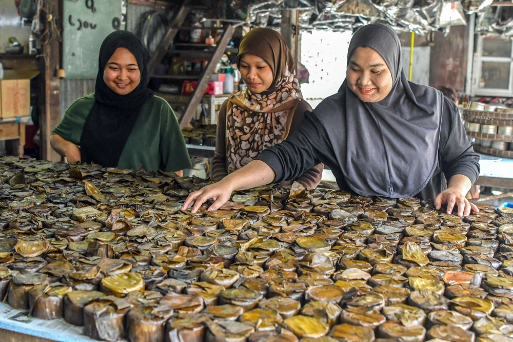 Workers Mawardah Mohd Yusof, 25 (right), Nur Alisya Nabila Othman, 19 (centre), and Auri Aslin Aslinda Mohd Rosli, 21 (left), inspect ‘kuih bakul’ before sale ahead of the Chinese New Year celebrations at a traditional kuih factory in Kampung Cina near Gok Kapur Market, Kota Bharu. — Bernama pic