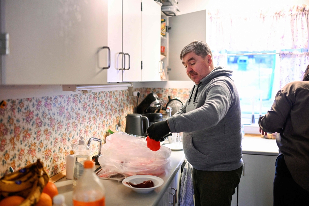 The husband of teacher Dorthe Olsen opens a bag of seal meat at their home of the settlement Sarfannguit, near Sisimiut, Greenland on February 1, 2026 where they refuse to let American turbulence disrupt their traditional daily life. — AFP pic