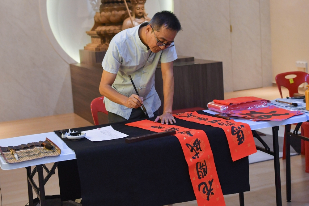 Kelantan Calligraphy Association treasurer Yeap Keng Hwa writes Chinese calligraphy as Chinese New Year decoration at Jalan Tok Hakim, Kota Bharu. — Bernama pic