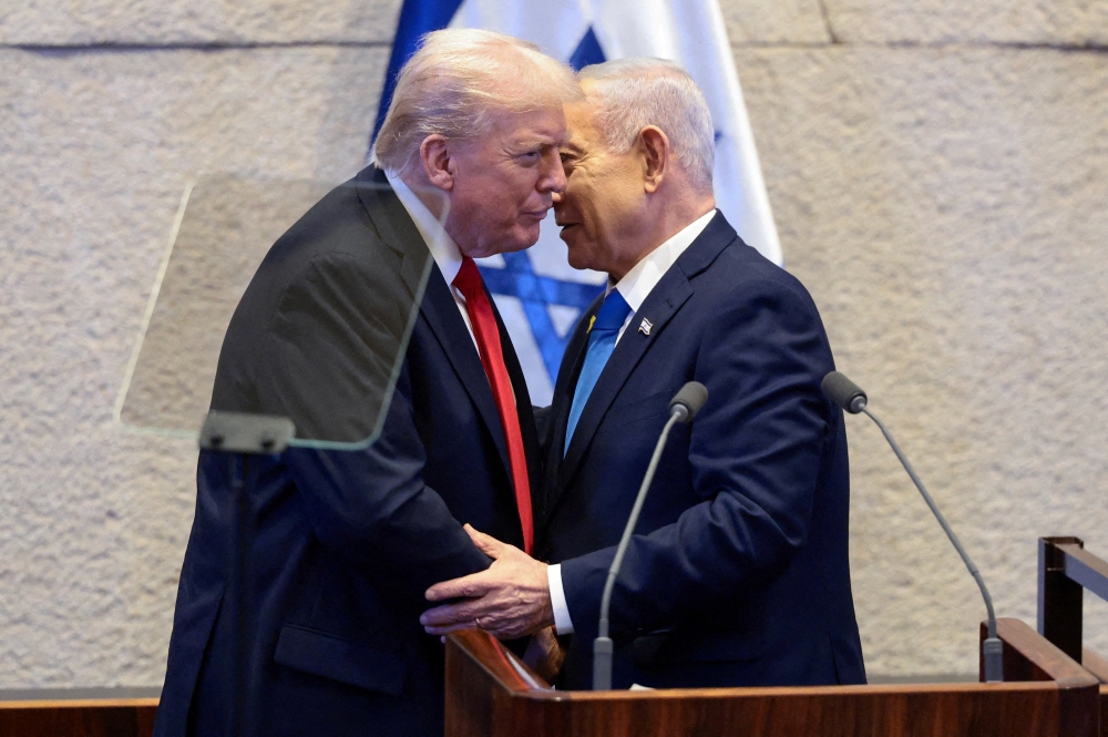 US President Donald Trump and Israeli Prime Minister Benjamin Netanyahu stand at the Knesset on the day Trump addresses it, amid a US-brokered prisoner-hostage swap and ceasefire deal between Israel and Hamas, in Jerusalem October 13, 2025. — Reuters pic