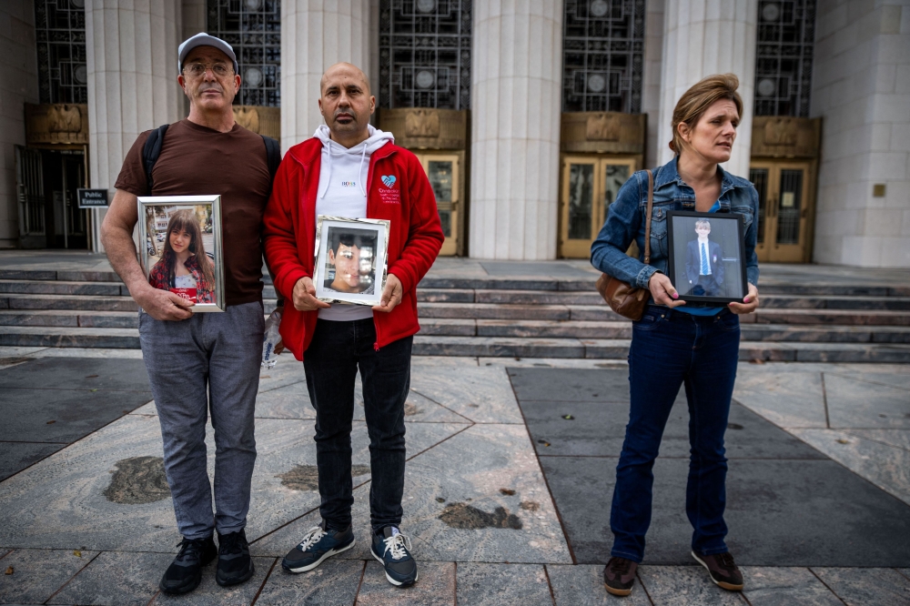 Family members hold photos of their children outside the Los Angeles Superior Court in Los Angeles on February 11, 2026. — AFP pic