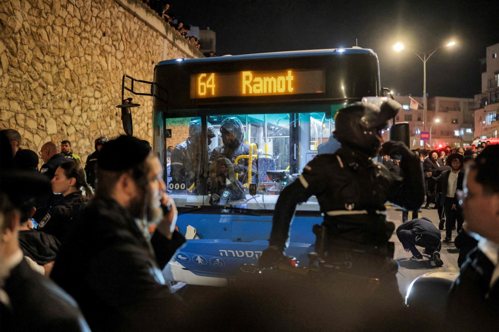 First responders surround a bus in Jerusalem on January 6, 2026, after it reportedly hit ultra-Orthodox Jewish protesters. Arab bus drivers say racist attacks have surged since the Gaza war began in October 2023, and accuse authorities of failing to curb the violence or hold perpetrators accountable. — AFP pic