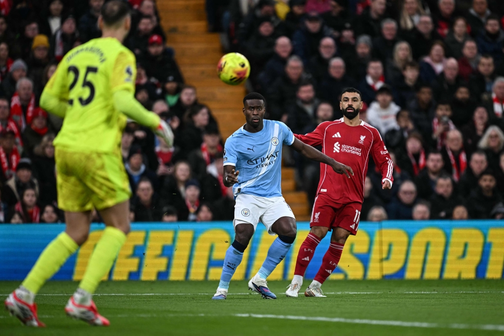 Liverpool's Egyptian striker #11 Mohamed Salah (right) hits a cross as Manchester City's English defender #15 Marc Guehi (centre) defends during the English Premier League football match between Liverpool and Manchester City at Anfield in Liverpool, north west England on February 8, 2026. — AFP pic 