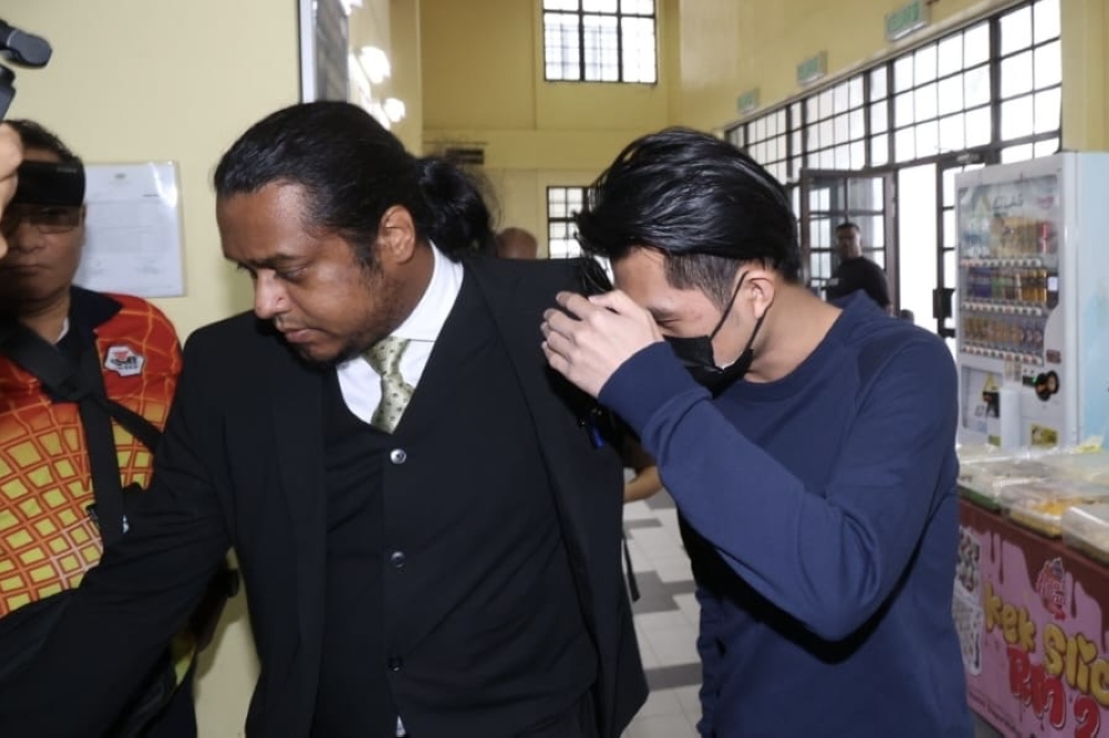 The accused is escorted by his defence lawyer, Mark Jeyakumar, into the Johor Bahru Magistrate’s Court February 13, 2026. — Picture by Ben Tan