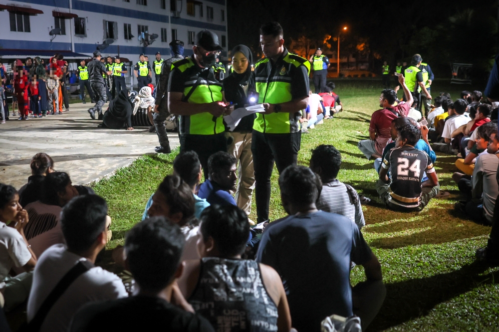 Selangor Immigration Department officers inspect foreign nationals detained during an integrated operation led by the Selangor State Immigration Department at an old apartment in Bukit Beruntung in Hulu Selangor early this morning, February 13, 2026. — Bernama pic 