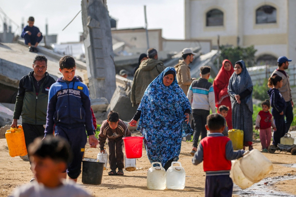 People fill up water containers from a mobile cistern in the Maghazi camp for Palestinian refugees in the central Gaza Strip on February 11, 2026. — AFP pic