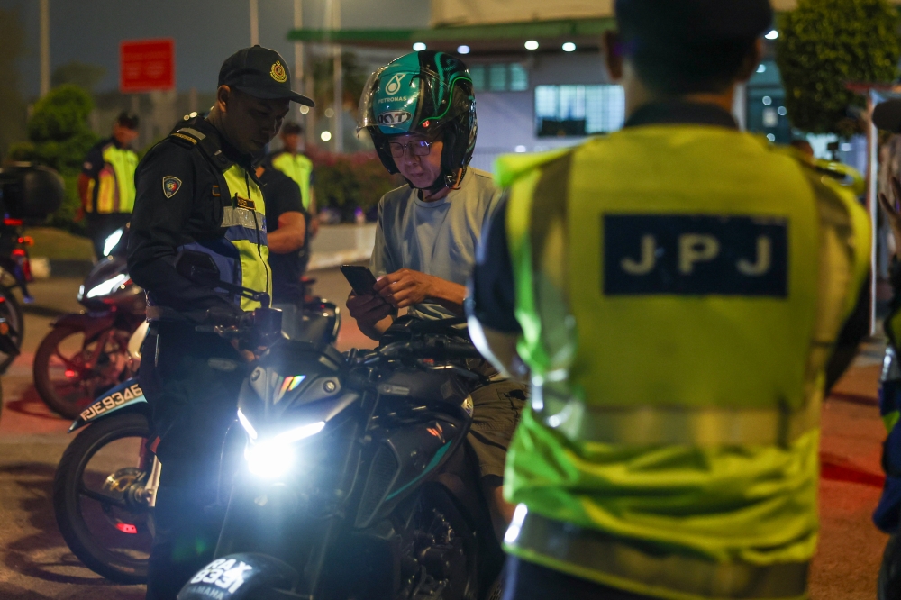 Penang JPJ officers conduct checks during the 2026 Chinese New Year special operation at the Penang Bridge last night. — Bernama pic