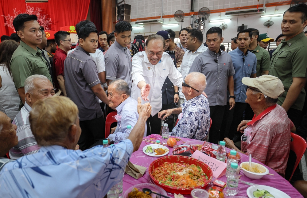 Prime Minister Datuk Seri Anwar Ibrahim greets members of the public during the Chinese New Year celebration with residents of Tambun at SJKC Chong Hwa Kanthan today. — Bernama pic