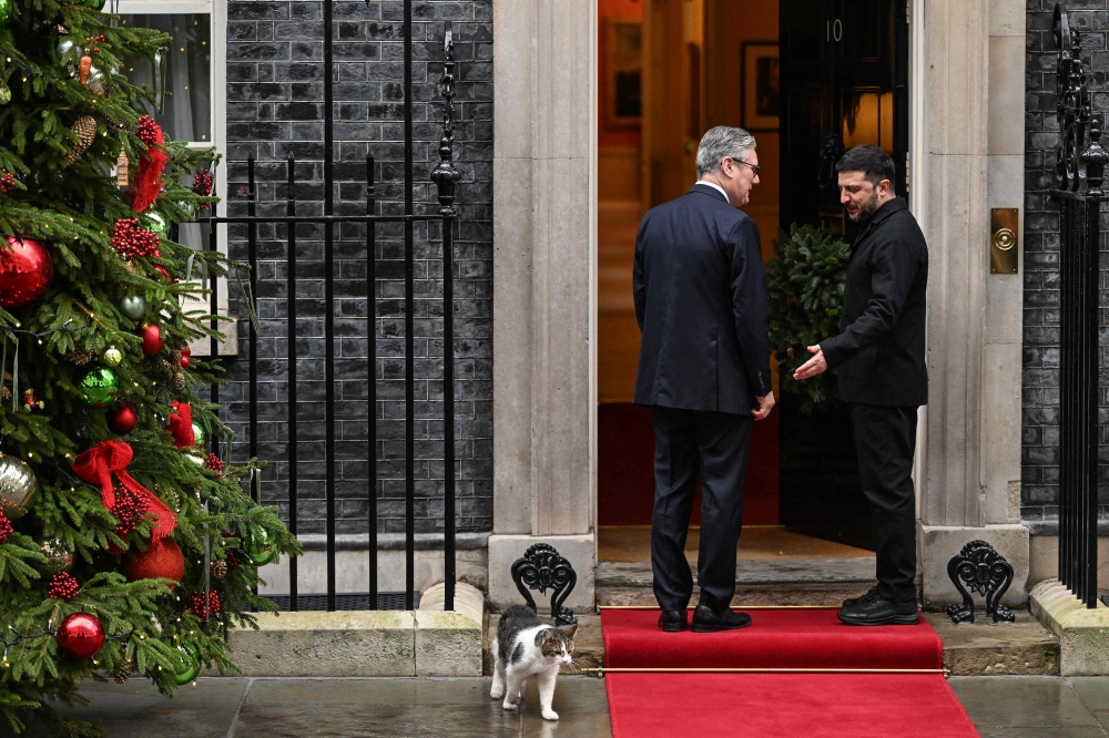 Britain's Prime Minister Keir Starmer (left) welcomes Ukraine's President Volodymyr Zelensky (right) upon his arrival as Larry the Downing Street cat (bottom left) walks away at Number 10 Downing Street in central London on December 8, 2025, as the leaders of Britain, France, Germany and Ukraine meet for talks. — AFP pic 