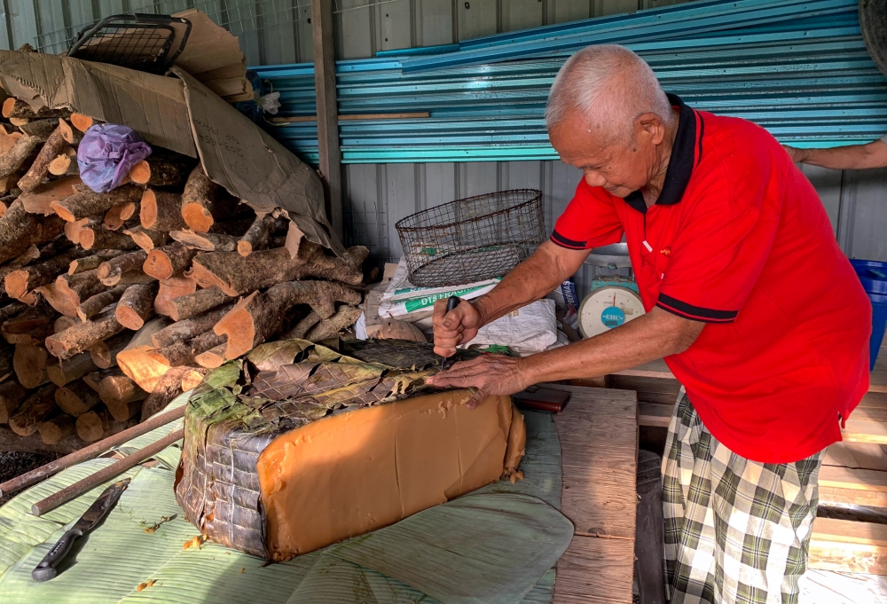 Traditional cake maker Wee Ah Liong slices a ‘Kiam Koay’, known as ‘Kia Koi’ in the Kelantan dialect, to weigh before selling to customers at Kampung Pasir Parit, Chekok recently. — Bernama pic 