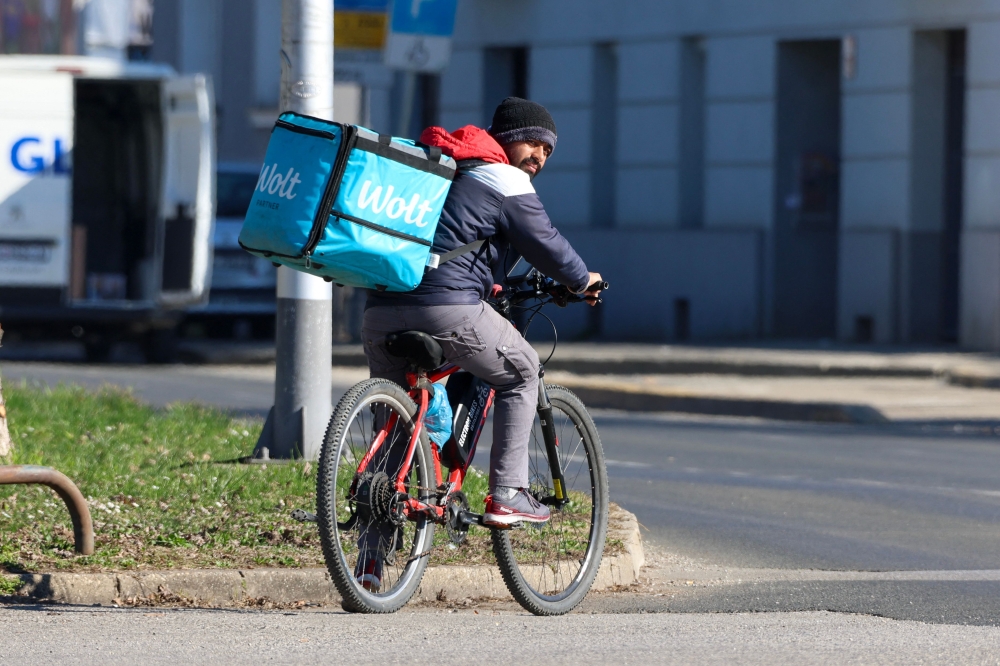 A foreign delivery worker rides a bicycle in downtown Zagreb on February 3, 2026. — AFP pic 