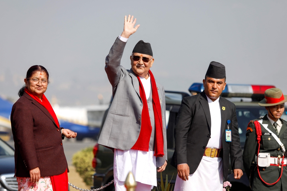 File picture of Nepal’s Prime Minister Khadga Prasad Sharma Oli (2nd left) waving alongside his wife Radhika Shakya (left) before his departure, at the Tribhuvan International airport in Kathmandu on December 2, 2024. — AFP pic 