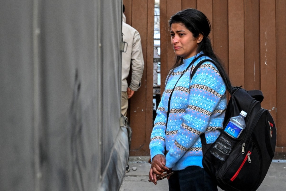This photograph taken on January 21, 2026 shows a relative of migrant worker Rudra Bahadur Kami mourning as his coffin is loaded onto a truck upon its arrival at Tribhuvan International Airport in Kathmandu. — AFP pic