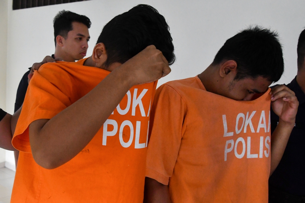 Muhamad Afezi Alias, 25, (left) pleaded not guilty at the Sessions Court in Pasir Mas, Kelantan, today to two charges of possessing a pistol and ammunition without a valid permit on February 6. — Bernama pic 