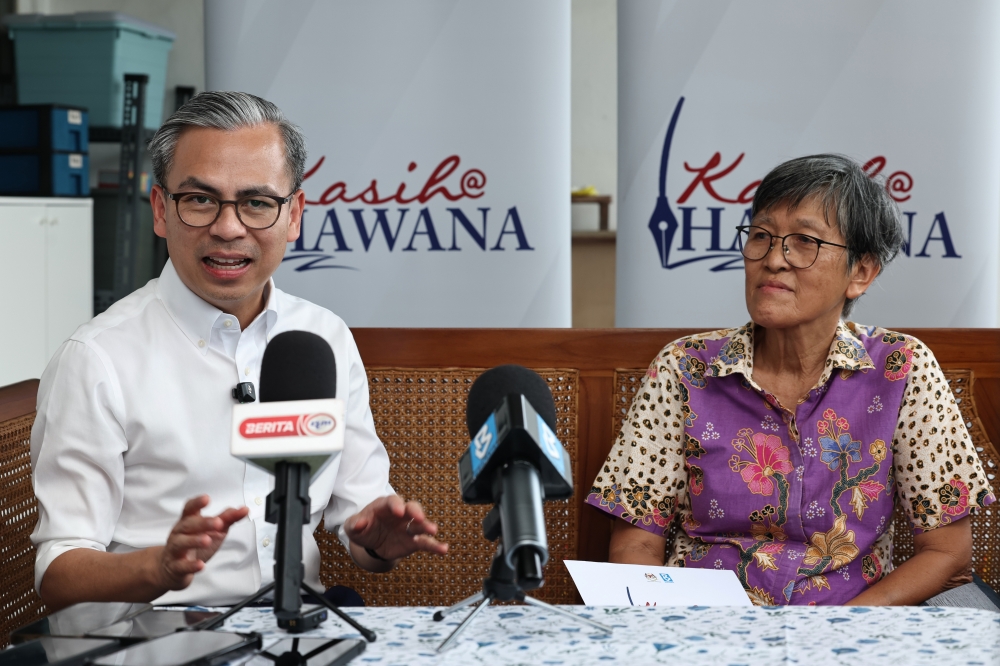 Communications Minister Datuk Fahmi Fadzil (left) speaks with former Oriental Daily journalist Low Sock Ken, 68, during a visit to present Tabung Kasih@Hawana assistance at her home in Taman Ungku Tun Aminah, Johor Bahru, February 16, 2026. — Bernama pic