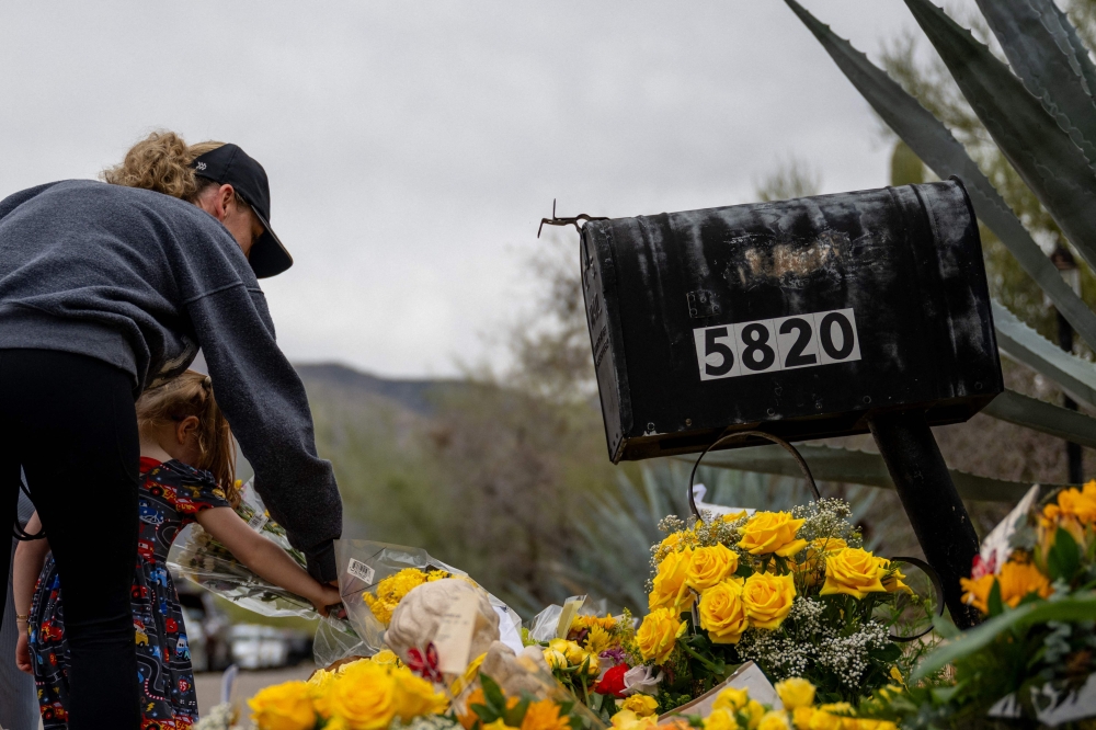 People pay their respects at a makeshift memorial outside the residence of Nancy Guthrie in Tucson, Arizona on February 16, 2026. — AFP pic