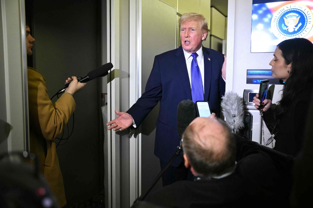 US President Donald Trump speaks to reporters aboard Air Force One en route to Joint Base Andrews from West Palm Beach, Florida, February 16, 2026. — AFP pic