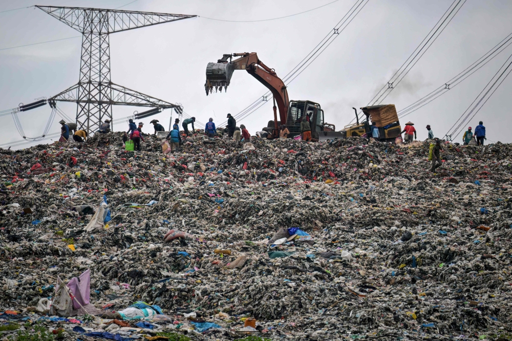 Heavy machinery is levelling a massive pile of waste at the Cipayung landfill in Depok, West Java, which often slides and clogs the river, sending waste to the outskirts of Jakarta during heavy rains. — AFP pic