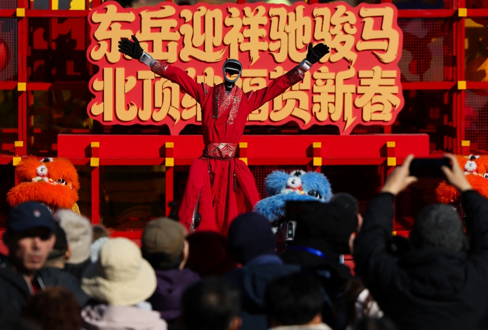People watch as a humanoid robot performs a dance during celebrations on the first day of the Lunar New Year of the Horse at the Niangniang Temple in Beijing, China on February 17, 2026. — Reuters pic