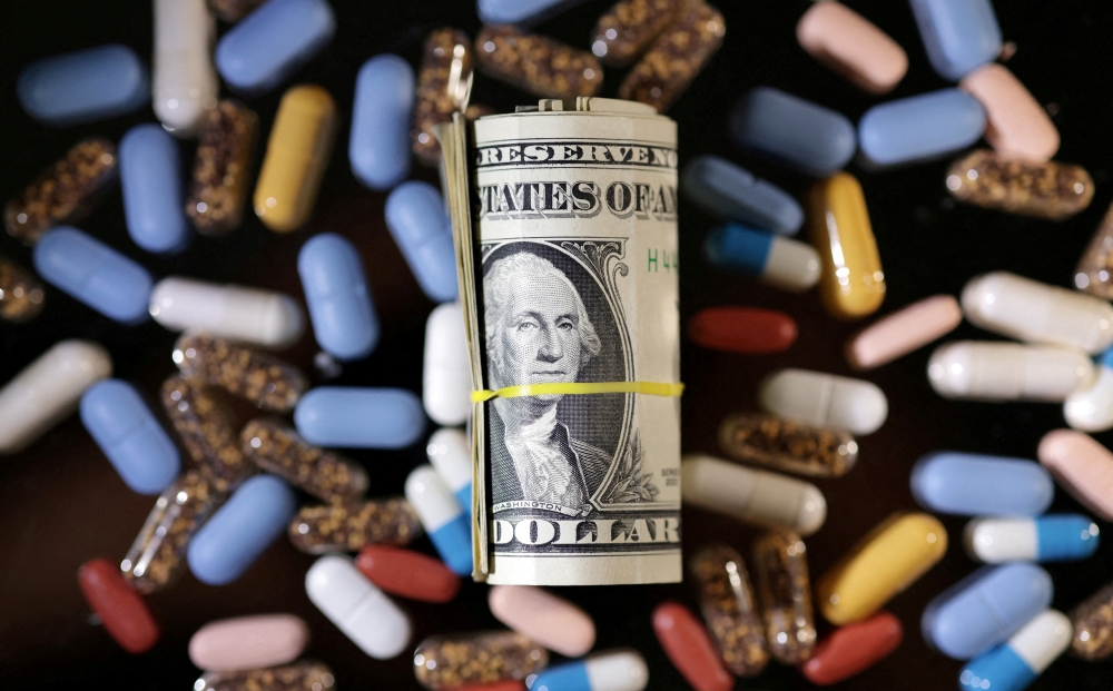 US dollar banknotes and medicines are pictured in this illustration taken on June 27, 2024. — Reuters pic