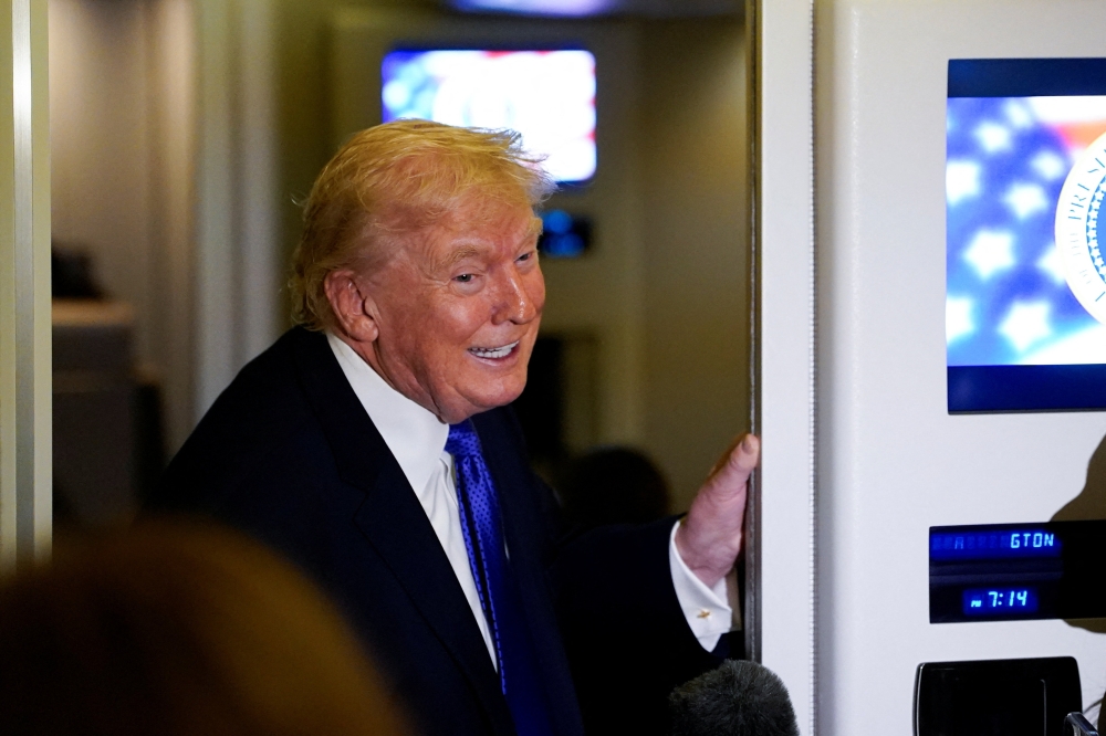 US President Donald Trump reacts as he speaks to reporters onboard Air Force One during travel from West Palm Beach, Florida, to Joint Base Andrews, Maryland on February 16, 2026. — Reuters pic