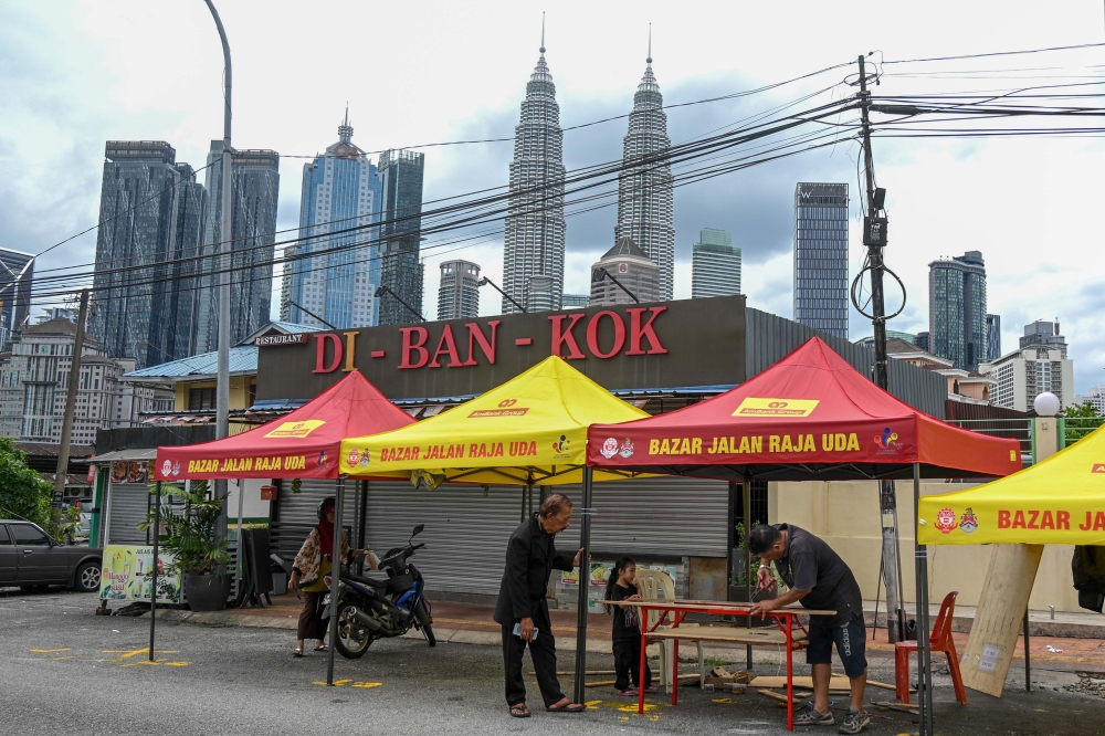 As Muslims begin fasting tomorrow, trader Zain Mohd, 62 (right), diligently sets up a Ramadan bazaar tent at Jalan Raja Uda, Kampung Baru, February 18, 2026. — Bernama pic 