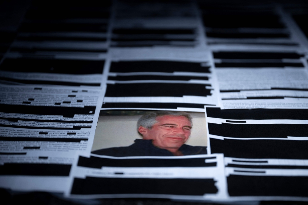 This photo illustration shows redacted documents from the Epstein Library files released by the US Department of Justice in Washington, DC, on February 18, 2026. — AFP pic 