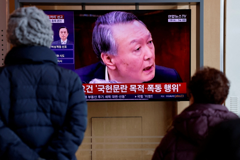 People watch a news report on the sentencing trial of South Korean former president Yoon Suk-yeol’s insurrection case. — Reuters pic