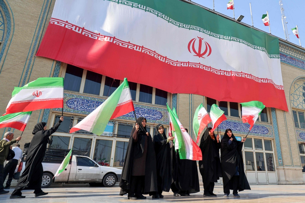 Women wave Iranian flags during a memorial marking 40 days of mourning for victims of recent unrest in Tehran on February 17, 2026. — AFP pic