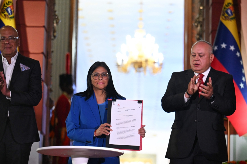 Venezuela’s interim president Delcy Rodriguez (centre) holds the amnesty law approved by the National Assembly, accompanied by the president of the Assembly Jorge Rodriguez (left) and the Minister of Interior, Justice and Peace Diosdado Cabello, at the Miraflores Palace in Caracas on February 19, 2026. Venezuela’s Parliament unanimously approved on February 19 a historic amnesty law that is expected to lead to the release of hundreds of political prisoners after 27 years of Chavismo. — AFP pic 