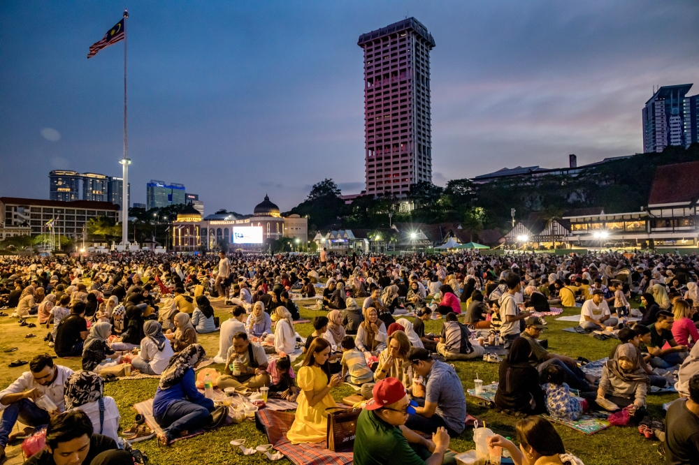Most Muslims at Dataran Merdeka took a picnic-style approach, bringing mats and home-cooked meals, supplemented by various delicacies purchased from nearby Ramadan bazaars. — Picture by Firdaus Latif