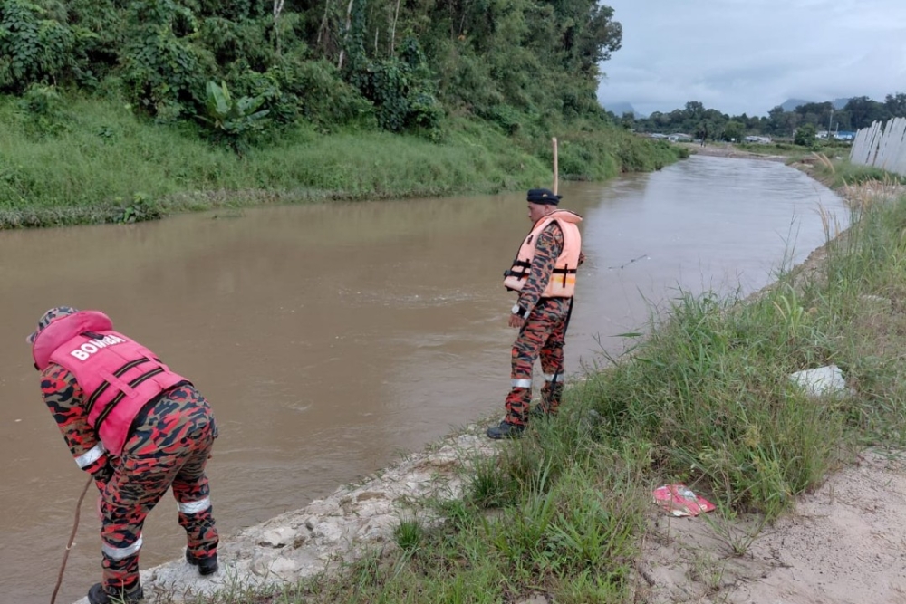 Bomba personnel conducting the search along the riverbank at Kampung Kolong Sungai Tengah in Petra Jaya. — Picture courtesy of Fire and Rescue Department 