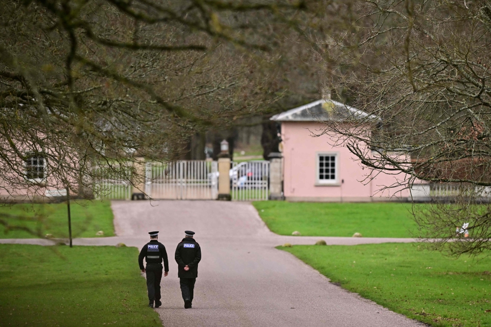 Police officers walk towards the entrance to Royal Lodge, a 30-room property and former residence of Britain's former Prince Andrew. — AFP pic