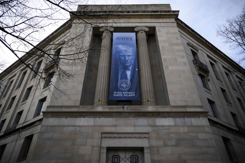 A new banner featuring an image of US President Donald Trump is displayed on the facade of the US Department of Justice headquarters, in Washington — AFP pic