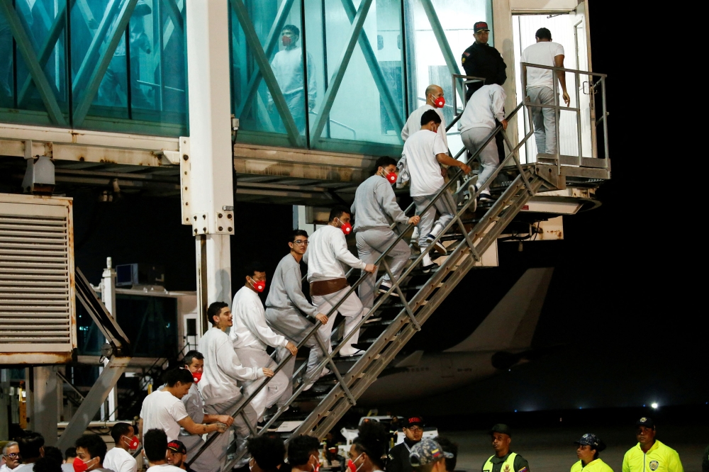 Venezuelan migrants flown from Guantanamo Bay via Honduras, walk up a ladder after arriving on a deportation flight at Simon Bolivar International Airport in Maiquetia, La Guaira State, Venezuela, February 20, 2025. — Reuters pic