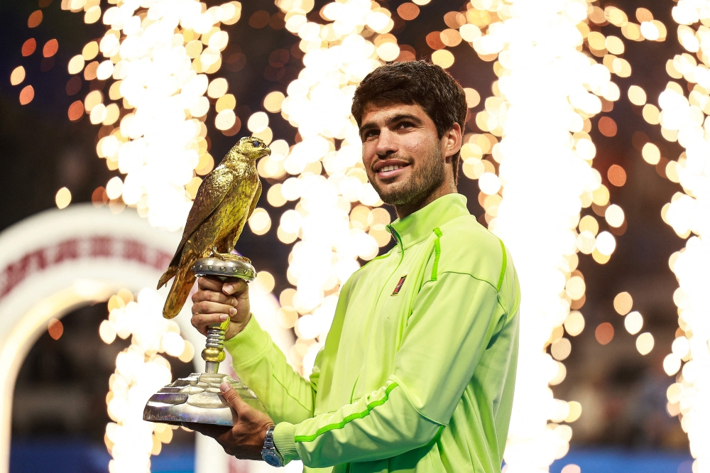 Spain’s Carlos Alcaraz celebrates with the trophy after defeating France’s Arthur Fils in the men’s singles final at the Qatar Open in Doha, February 21, 2026. — AFP pic