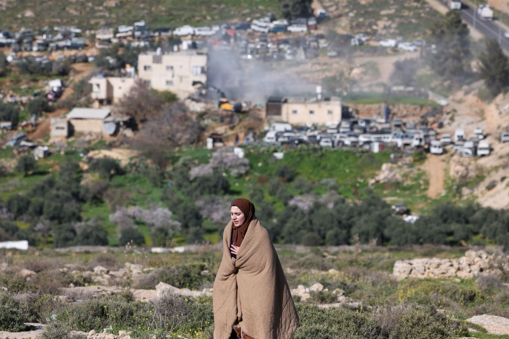 A Palestinian woman reacts as Israeli bulldozers demolish an apartment building belonging to the Salhab family near the Israeli settlement of Hagai, south of the occupied West Bank city of Hebron, on February 18, 2026. — AFP pic