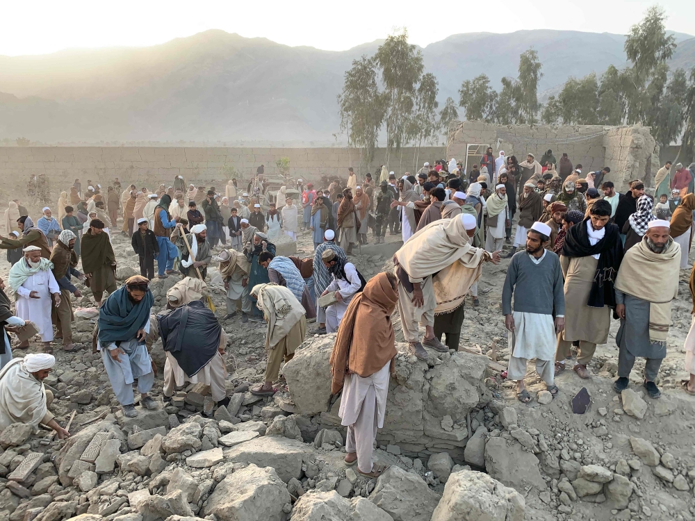 Afghan men search for victims after an overnight Pakistani airstrike hit a residential area in the Girdi Kas village of Bihsud district, Nangarhar province on February 22, 2026. — AFP pic