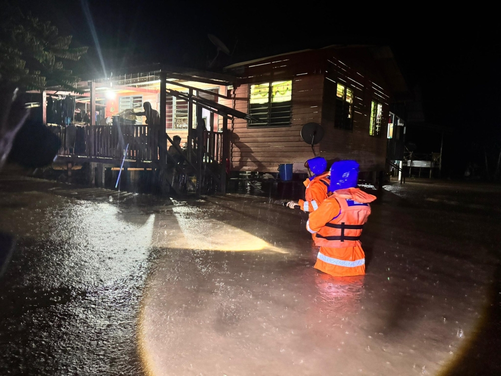 Rescuers make their way to a flooded home in Kota Marudu on January 20, 2026 as families await assistance during heavy overnight rain. — Picture via Facebook/APM Kota Marudu