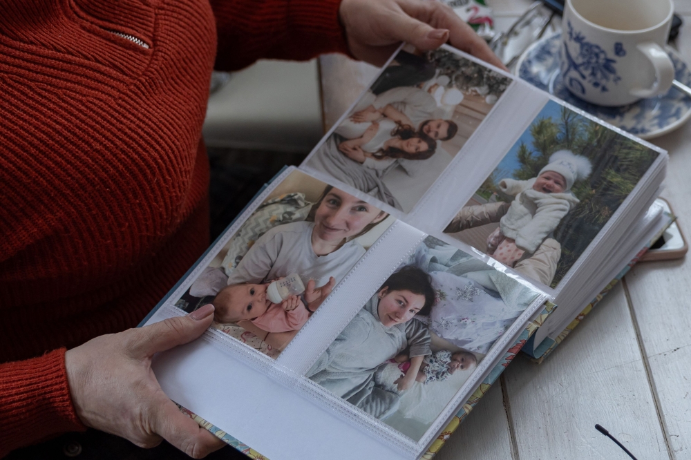 Nina, mother of fallen Ukrainian soldier Yuriy Glodan, shows photos of him, his three-month-old daughter Kira, and 28-year-old wife Valeria before their deaths in a missile attack in Odesa on February 20, 2026. — AFP pic