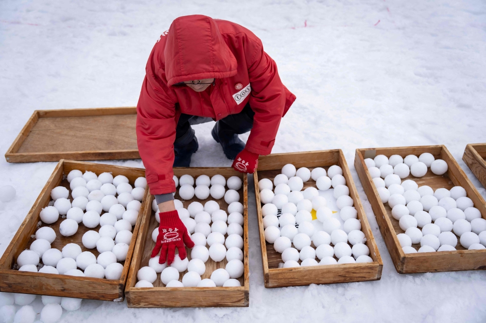 A referee counts snowballs ahead of a match during the Showa-shinzan International Yukigassen snowball fight competition in Sobetsu, Hokkaido prefecture on February 21, 2026. — AFP pic