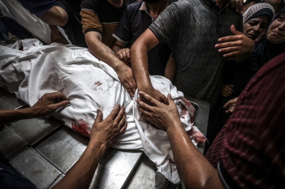 Friends and relatives mourn the death of Indonesian Hospital director doctor Marwan al-Sultan along with seven members of his family following an Israeli attack on an apartment located in 17th Junction in Gaza City, Gaza on July 2, 2025. — Anadolu via AFP pic
