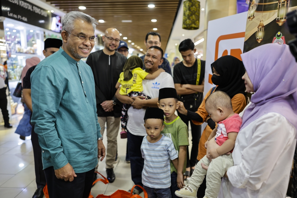 Federal Territories Islamic Religious Council (MAIWP) chairman Tan Sri Mohd Daud Bakar (left) meets 50 asnaf from five families to purchase Raya outfits at a shopping mall during the Rahmah Ramadan MAIWP Sinar Aidilfitri programme in Kuala Lumpur April 8, 2023. — Bernama pic